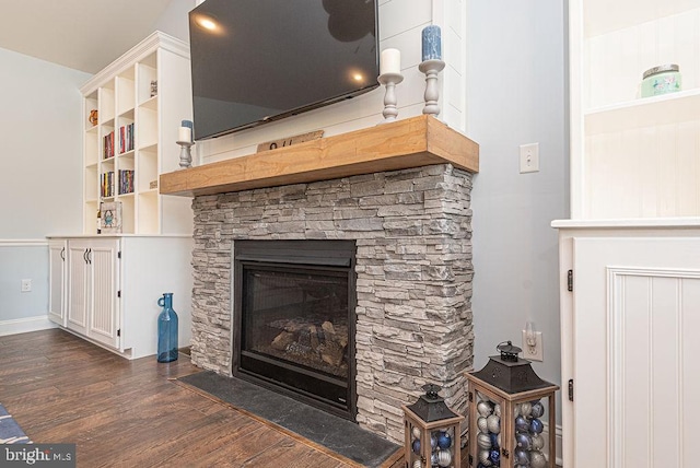 24440 Harvest Cir, Milton, DE 19968 - living room with a stone fireplace, dark wood-style floors, and baseboards