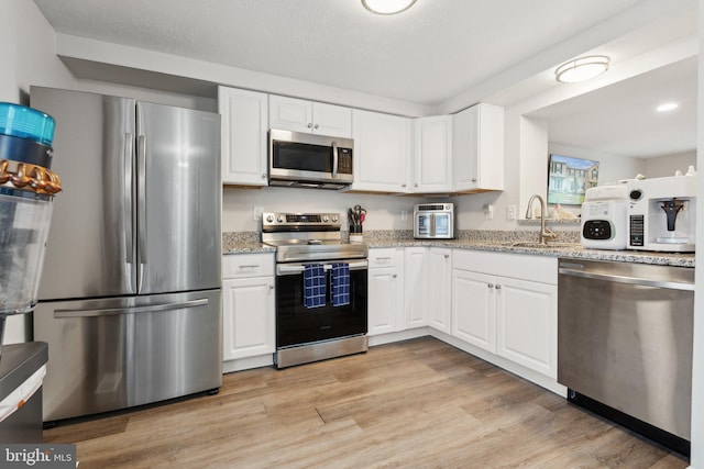 3146 Tipton Way, Abingdon, MD 21009 - kitchen with stainless steel appliances, white cabinetry, light stone counters, and light wood-type flooring