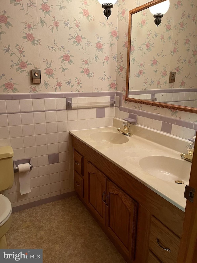 18 Bittersweet Dr, Hagerstown, MD 21740 - bathroom featuring wallpapered walls, double vanity, a wainscoted wall, toilet, and tile walls