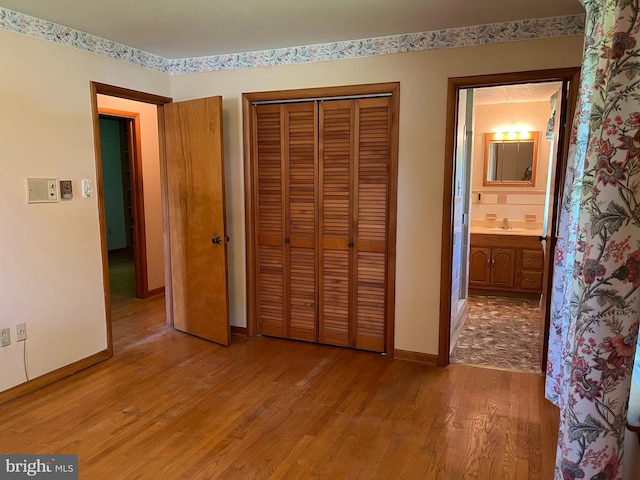 18 Bittersweet Dr, Hagerstown, MD 21740 - unfurnished bedroom with light wood-type flooring, baseboards, a sink, a closet, and ensuite bathroom