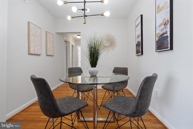 2605 39th St NW Unit 303, Washington, DC 20007 - dining room featuring light wood-type flooring, baseboards, and a chandelier