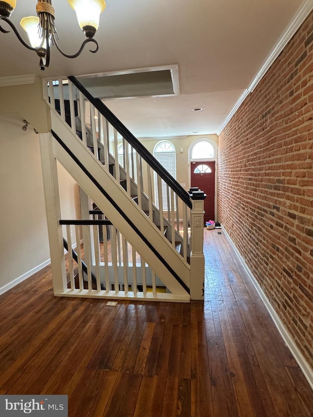1406 Clarkson St, Baltimore, MD 21230 - stairway with brick wall, a chandelier, hardwood / wood-style floors, and ornamental molding