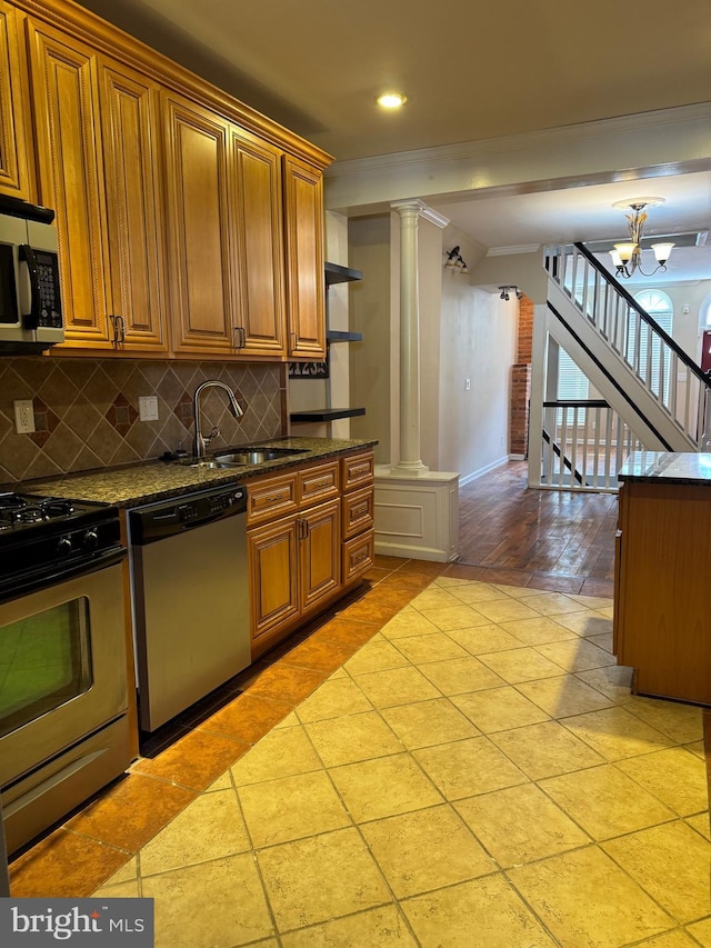 1406 Clarkson St, Baltimore, MD 21230 - kitchen featuring stainless steel appliances, ornate columns, decorative backsplash, ornamental molding, and brown cabinetry