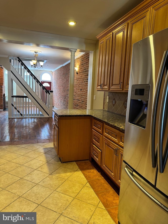 1406 Clarkson St, Baltimore, MD 21230 - kitchen with stainless steel fridge, ornate columns, brown cabinetry, a peninsula, and crown molding