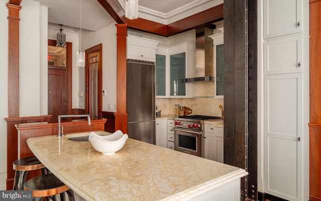 1830 Rittenhouse Sq Unit 11C, Philadelphia, PA 19103 - kitchen with high quality appliances, wall chimney exhaust hood, decorative columns, light countertops, and crown molding
