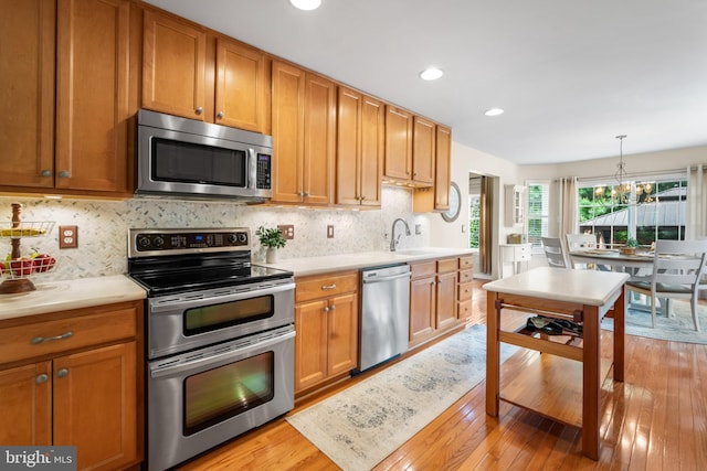 129 Bridle Path Dr, Egg Harbor Township, NJ 08234 - kitchen with stainless steel appliances, light countertops, a chandelier, light wood finished floors, and recessed lighting