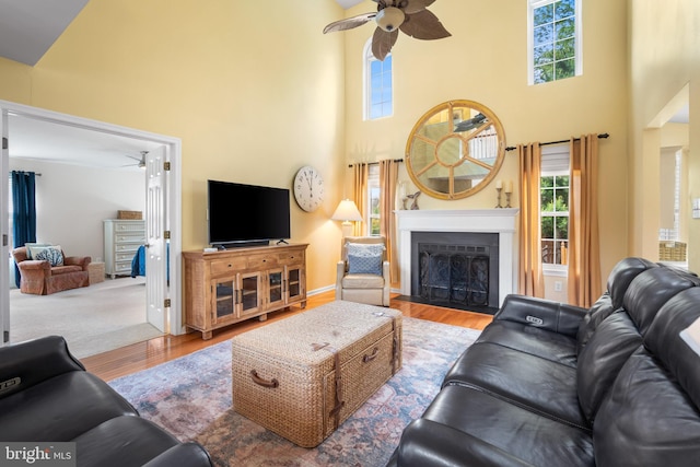 129 Bridle Path Dr, Egg Harbor Township, NJ 08234 - living area featuring a ceiling fan, wood finished floors, a towering ceiling, healthy amount of natural light, and a fireplace with flush hearth