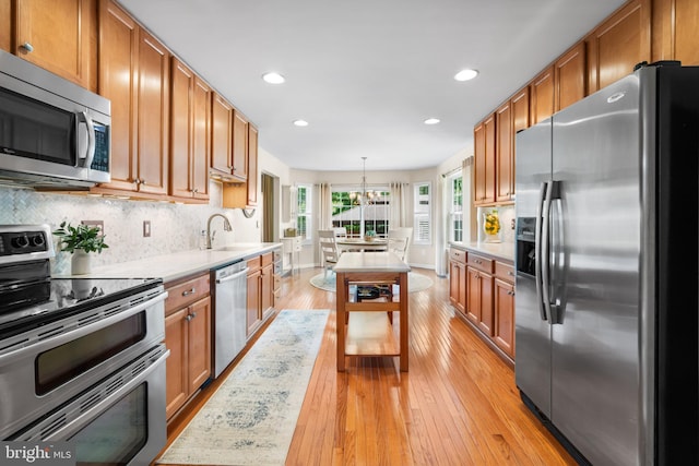 129 Bridle Path Dr, Egg Harbor Township, NJ 08234 - kitchen featuring stainless steel appliances, a chandelier, a sink, light countertops, and light wood-style floors