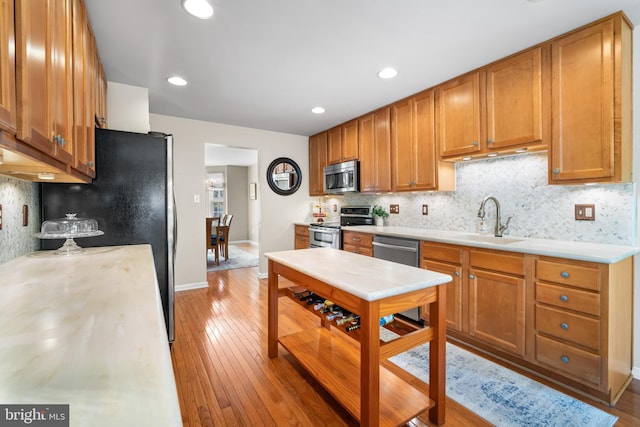 129 Bridle Path Dr, Egg Harbor Township, NJ 08234 - kitchen with stainless steel appliances, a sink, light wood-type flooring, decorative backsplash, and light countertops