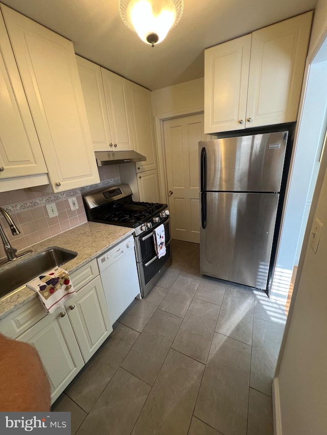 2108 26th St S, Arlington, VA 22206 - kitchen with appliances with stainless steel finishes, white cabinetry, under cabinet range hood, and tasteful backsplash
