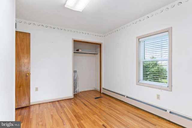 524 S Pitt St, Carlisle, PA 17013 - unfurnished bedroom with baseboard heating, light wood-type flooring, a closet, and baseboards