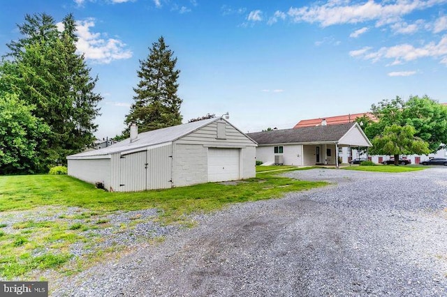 524 S Pitt St, Carlisle, PA 17013 - view of front of property featuring a garage, an outbuilding, gravel driveway, a front lawn, and a chimney