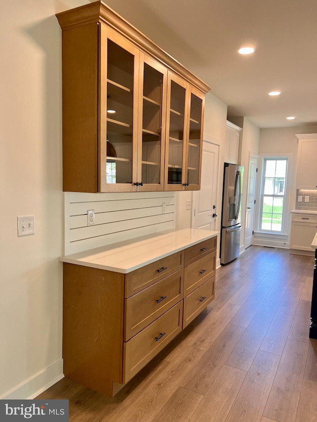 34232 Brenner Ln, Lewes, DE 19958 - kitchen with stainless steel fridge with ice dispenser, baseboards, wood finished floors, glass insert cabinets, and recessed lighting
