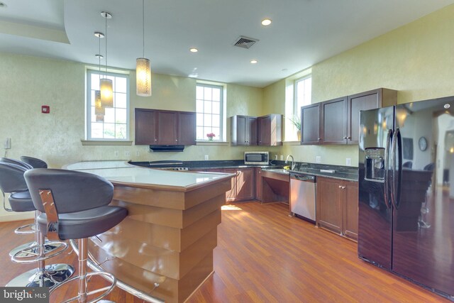 4149 S Four Mile Run Dr Unit 201, Arlington, VA 22204 - kitchen featuring stainless steel appliances, dark wood-style floors, recessed lighting, a sink, and a kitchen bar