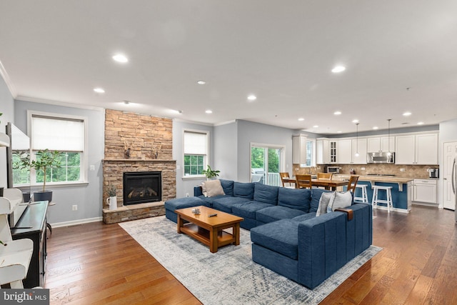 1509 Blakes Legacy Dr, Bel Air, MD 21014 - living room featuring dark wood-type flooring, recessed lighting, ornamental molding, and a stone fireplace