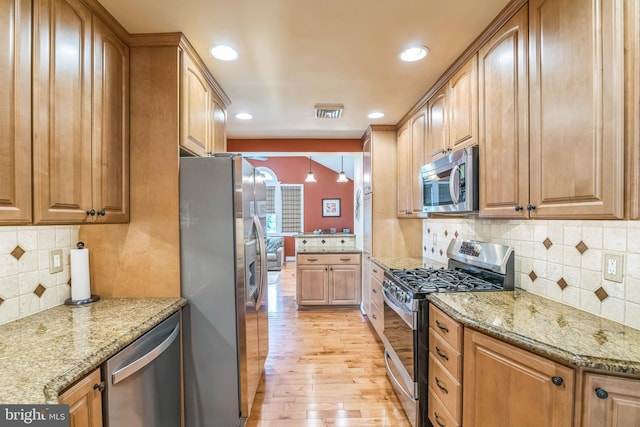 622 Hutchinson Ter, Holmes, PA 19043 - kitchen featuring appliances with stainless steel finishes, light wood-style flooring, backsplash, light stone countertops, and recessed lighting