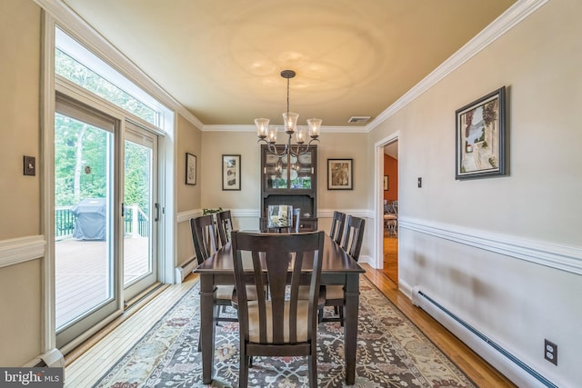 622 Hutchinson Ter, Holmes, PA 19043 - dining space with a baseboard heating unit, wood finished floors, a chandelier, crown molding, and wainscoting