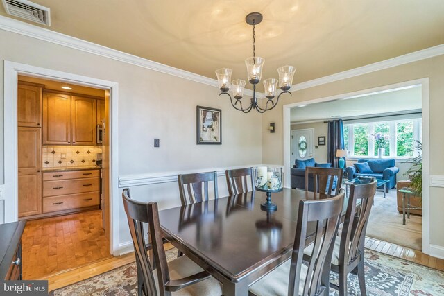 622 Hutchinson Ter, Holmes, PA 19043 - dining space with crown molding, a chandelier, and light wood-style flooring