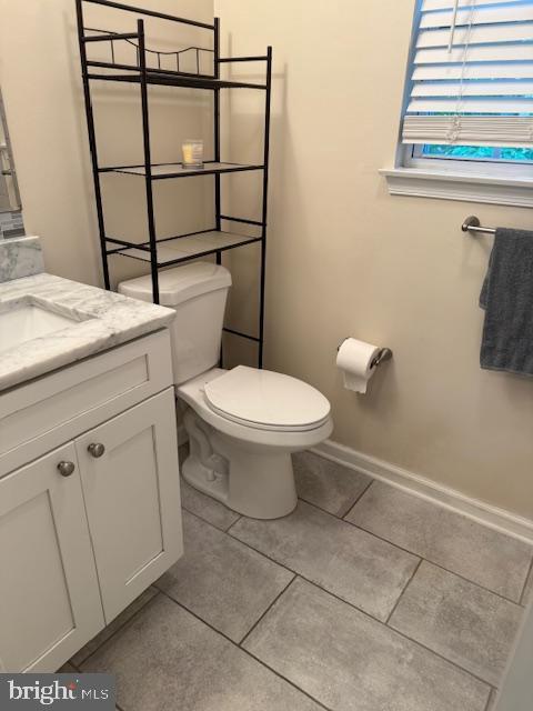 10024 Park Woods Ln, Burke, VA 22015 - half bath featuring vanity, toilet, tile patterned floors, and baseboards