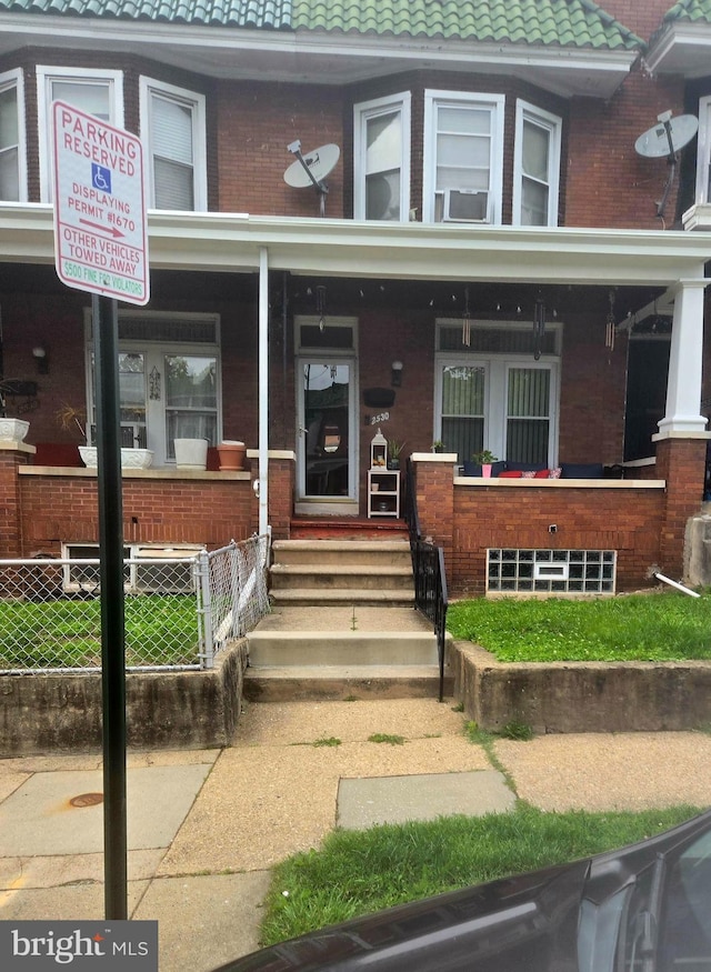 2530 Arunah Ave, Baltimore, MD 21216 - view of front of property with covered porch, brick siding, and a tiled roof