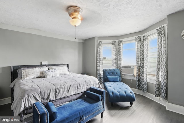 2530 Arunah Ave, Baltimore, MD 21216 - bedroom with cooling unit, wood finished floors, baseboards, multiple windows, and a textured ceiling