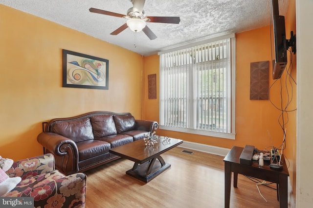 2530 Arunah Ave, Baltimore, MD 21216 - living room with a textured ceiling, wood finished floors, a ceiling fan, and baseboards