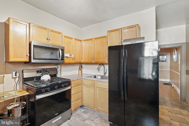 2530 Arunah Ave, Baltimore, MD 21216 - kitchen with stainless steel appliances, a sink, light brown cabinets, and stone finish flooring