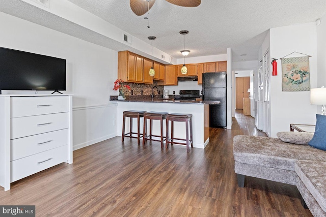 203 33rd St Unit 407, Ocean City, MD 21842 - kitchen featuring black appliances, range hood, open floor plan, dark countertops, and a peninsula