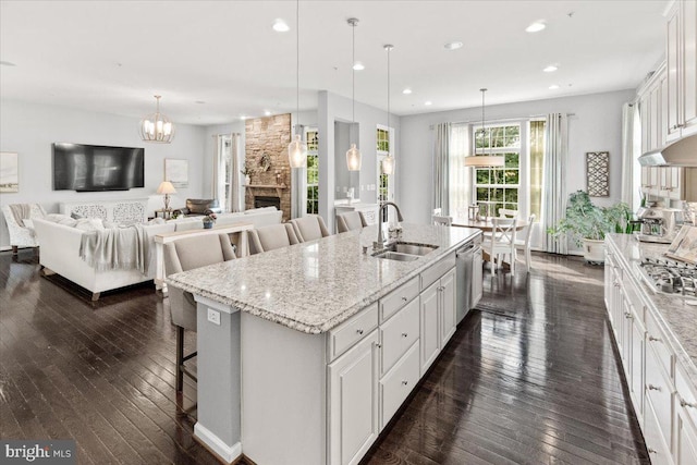 6808 Rehnquist Ct, New Market, MD 21774 - kitchen featuring a sink, a breakfast bar, dark wood-type flooring, a fireplace, and white cabinetry