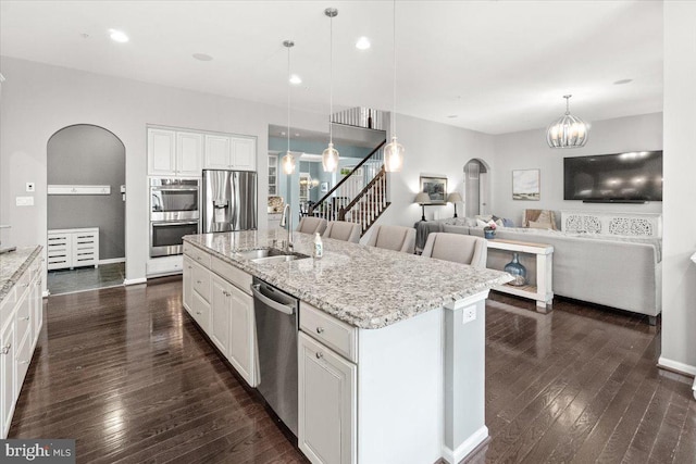 6808 Rehnquist Ct, New Market, MD 21774 - kitchen with appliances with stainless steel finishes, a sink, arched walkways, and dark wood-type flooring
