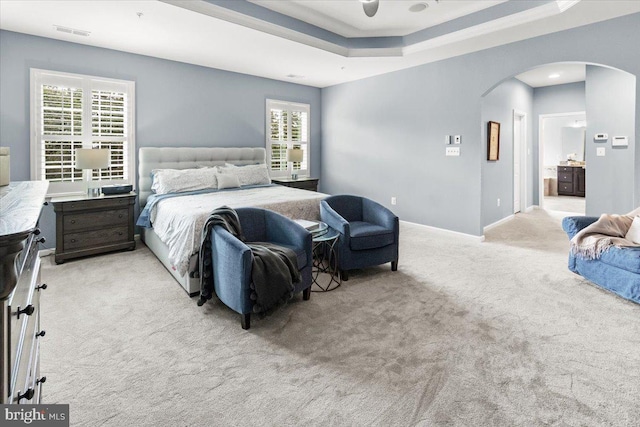 6808 Rehnquist Ct, New Market, MD 21774 - bedroom featuring arched walkways, light colored carpet, a raised ceiling, ensuite bath, and baseboards