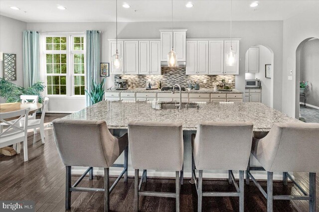 6808 Rehnquist Ct, New Market, MD 21774 - kitchen with a sink, appliances with stainless steel finishes, arched walkways, dark wood-style flooring, and backsplash