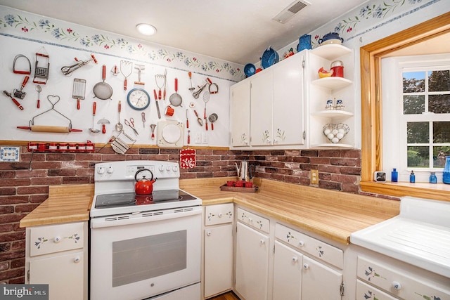 787 Park Rd, Lansdale, PA 19446 - kitchen featuring white electric range, open shelves, plenty of natural light, light countertops, and brick wall