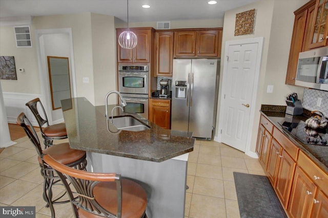 11516 Mystic Rock Ln N, Waynesboro, PA 17268 - kitchen with stainless steel appliances, a sink, a breakfast bar, backsplash, and light tile patterned flooring