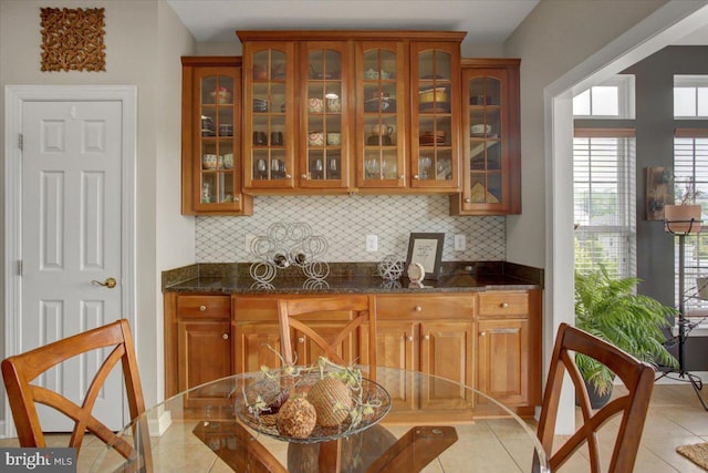 11516 Mystic Rock Ln N, Waynesboro, PA 17268 - kitchen with brown cabinetry, backsplash, glass insert cabinets, and dark stone countertops
