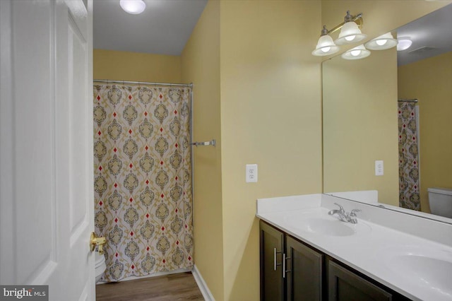 11516 Mystic Rock Ln N, Waynesboro, PA 17268 - bathroom with double vanity, wood finished floors, toilet, baseboards, and a shower with shower curtain