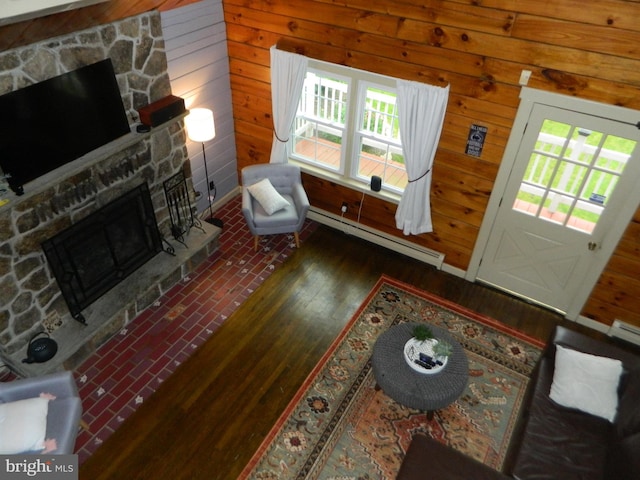 126 Ivy Ln, Lock Haven, PA 17745 - living room with a baseboard radiator, a stone fireplace, wood finished floors, and wood walls
