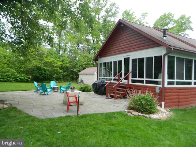 126 Ivy Ln, Lock Haven, PA 17745 - back of house featuring a sunroom, a patio area, a lawn, an outdoor fire pit, and roof with shingles