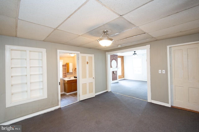 217 W End Ave, Cambridge, MD 21613 - empty room featuring a paneled ceiling, dark colored carpet, a ceiling fan, and baseboards