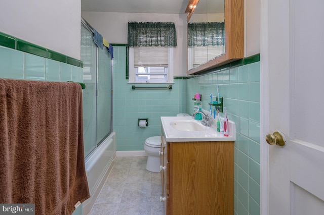 224 W Underwood Ave, West Deptford, NJ 08096 - full bath with tile walls, vanity, toilet, tile patterned flooring, and shower / bath combination with glass door