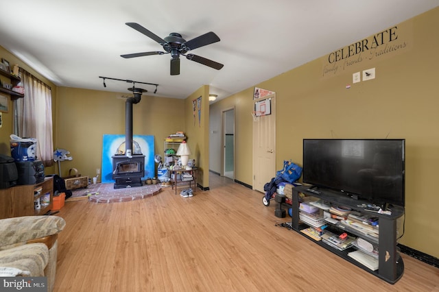 224 W Underwood Ave, West Deptford, NJ 08096 - living room with a wood stove, a ceiling fan, wood finished floors, and baseboards