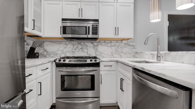 1323 Clifton St NW Unit 34, Washington, DC 20009 - kitchen with appliances with stainless steel finishes, white cabinetry, tasteful backsplash, and light stone counters