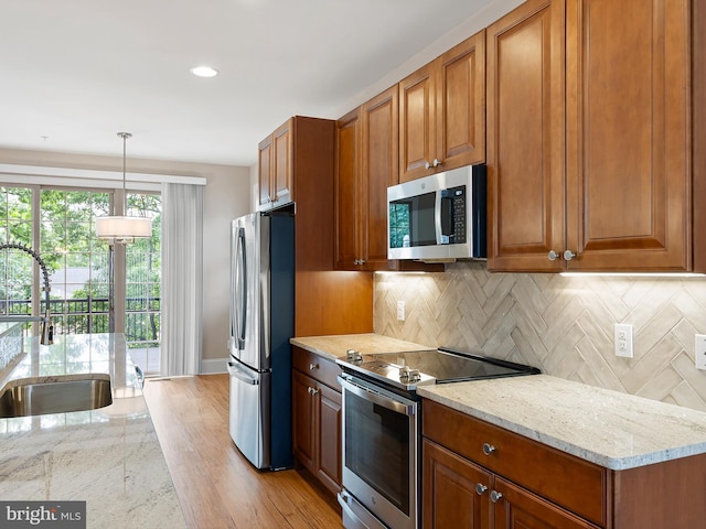 105 Sutton Way, Newark, DE 19711 - kitchen with stainless steel appliances, a sink, light stone countertops, brown cabinetry, and recessed lighting