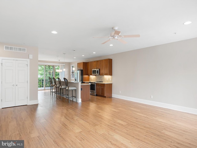105 Sutton Way, Newark, DE 19711 - kitchen with appliances with stainless steel finishes, brown cabinets, light wood-type flooring, light countertops, and tasteful backsplash