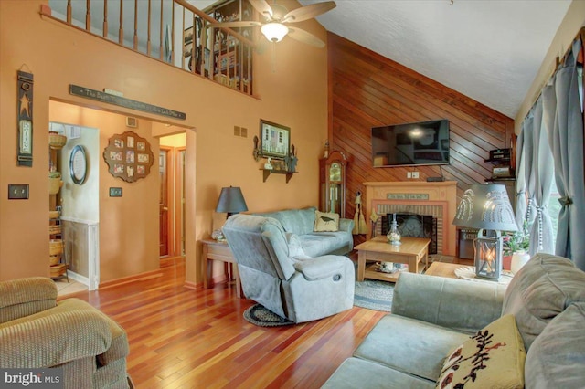 50 Valleyview Dr, Littlestown, PA 17340 - living area featuring high vaulted ceiling, wood walls, wood finished floors, ceiling fan, and a brick fireplace