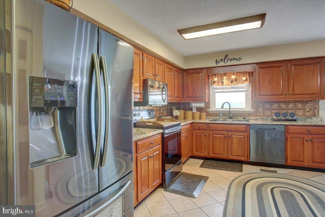 50 Valleyview Dr, Littlestown, PA 17340 - kitchen featuring stainless steel appliances, a sink, backsplash, light tile patterned flooring, and brown cabinetry