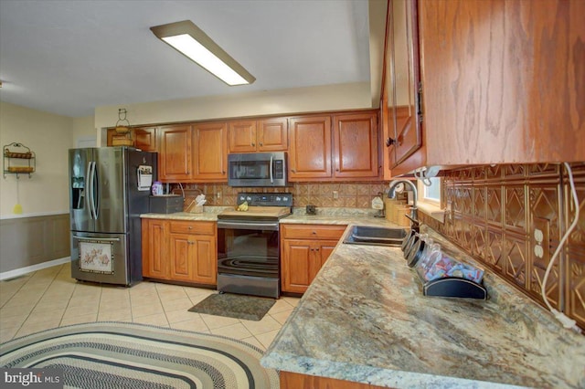 50 Valleyview Dr, Littlestown, PA 17340 - kitchen featuring appliances with stainless steel finishes, a sink, tasteful backsplash, light tile patterned floors, and brown cabinets