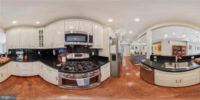 422 Hamilton St NW, Washington, DC 20011 - kitchen with stainless steel appliances, dark countertops, a sink, dark wood finished floors, and glass insert cabinets