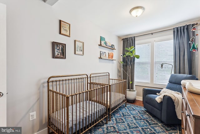 422 Hamilton St NW, Washington, DC 20011 - bedroom featuring baseboards, wood finished floors, and a crib