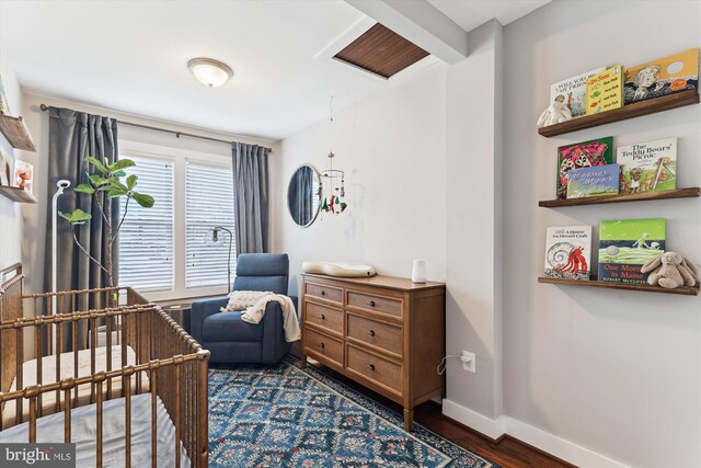 422 Hamilton St NW, Washington, DC 20011 - bedroom featuring a crib, dark wood-style floors, and baseboards